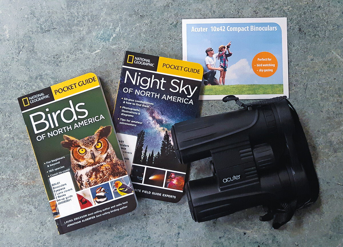 Large black binoculars with two books: Birds of North America and Night Sky of North America
